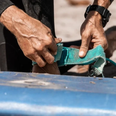 Amarrando tabla de surf al pie en famara